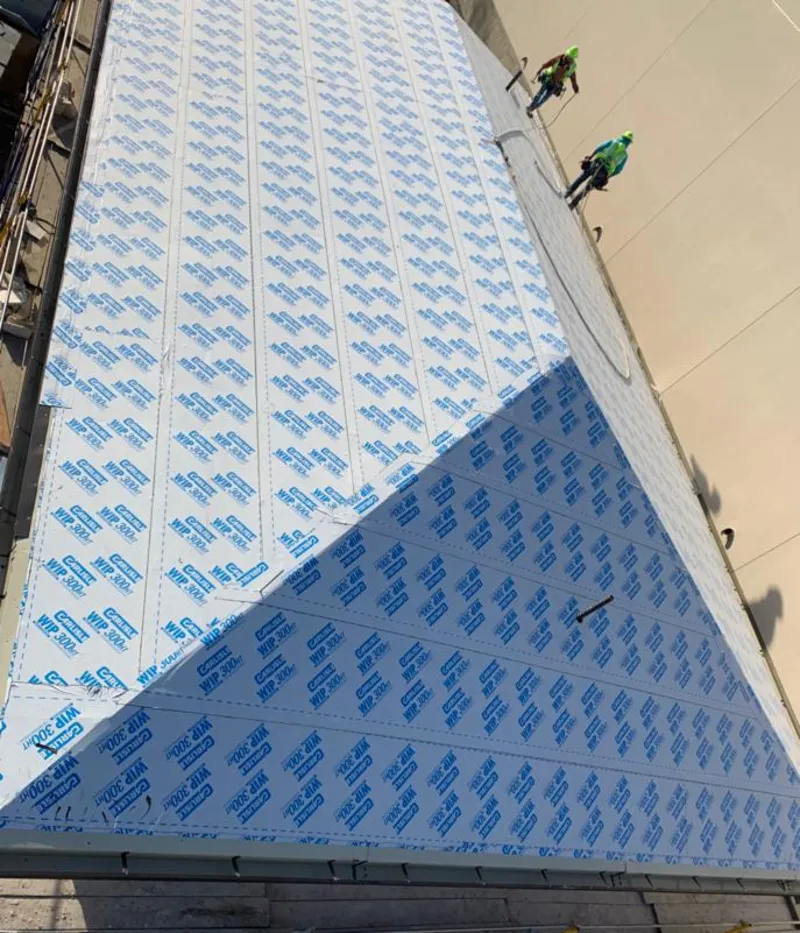 Professional roofers installing underlayment on a metal roof in Bryn Mawr-Skyway